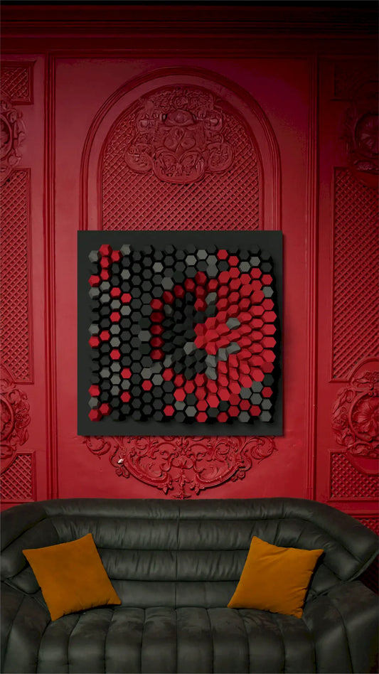 Decorative wall art with red and black pattern on a red textured wall above a black sofa with orange cushions.